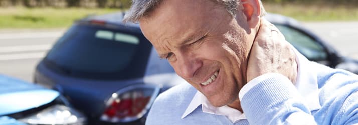 Adult man holding his neck after a car accident — auto injury chiropractic in Hurst, Texas